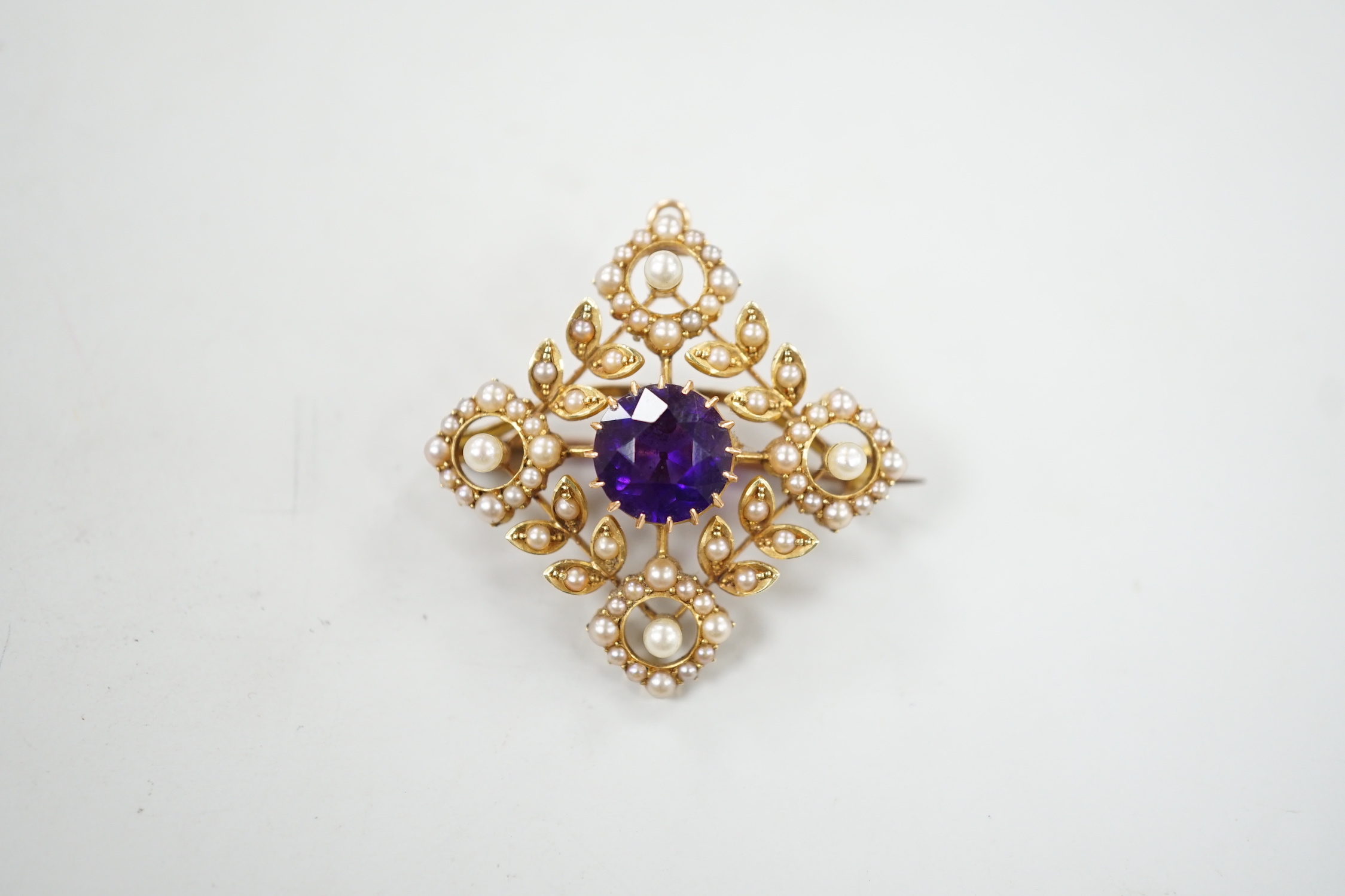 An Edwardian yellow metal, amethyst and seed pearl cluster set pendant brooch, 33mm, gross weight 7.4 grams.